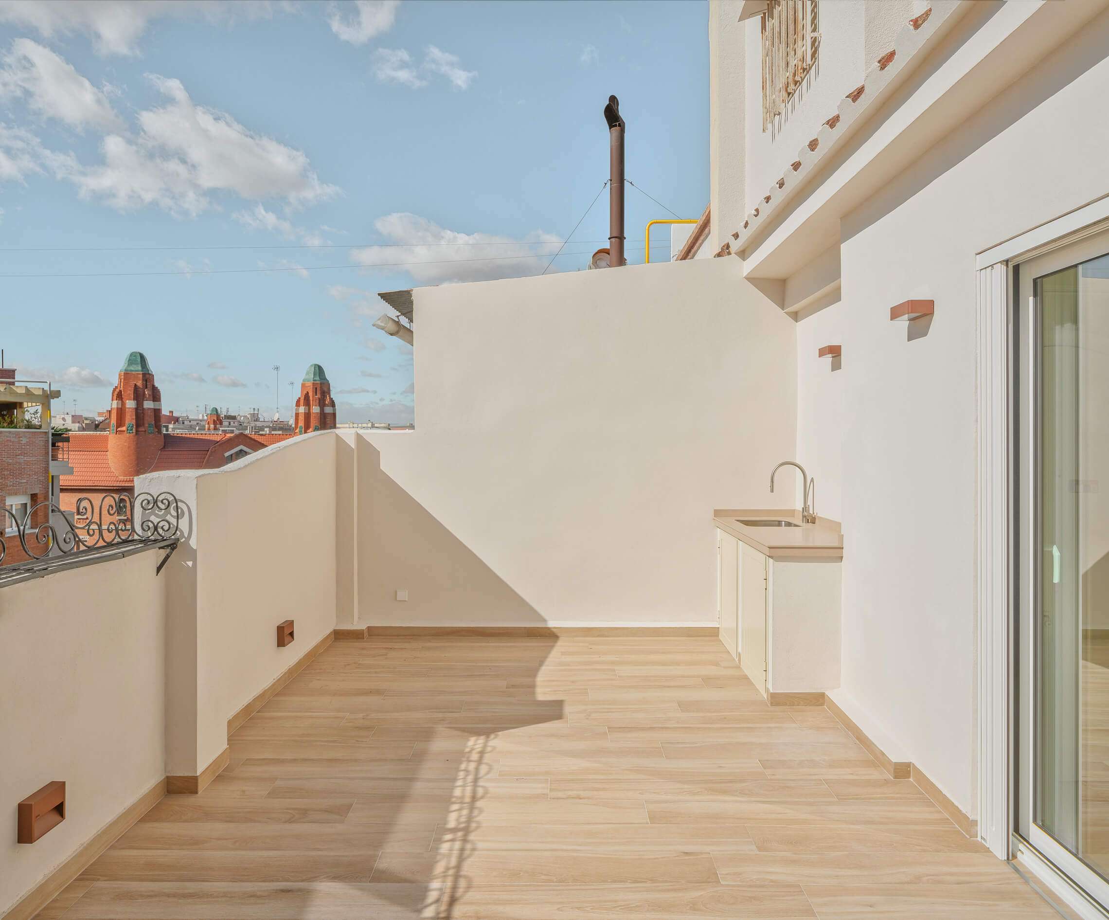 foto de la terraza de un ático muy luminoso. De fondo se ve la finca roja de Valencia.