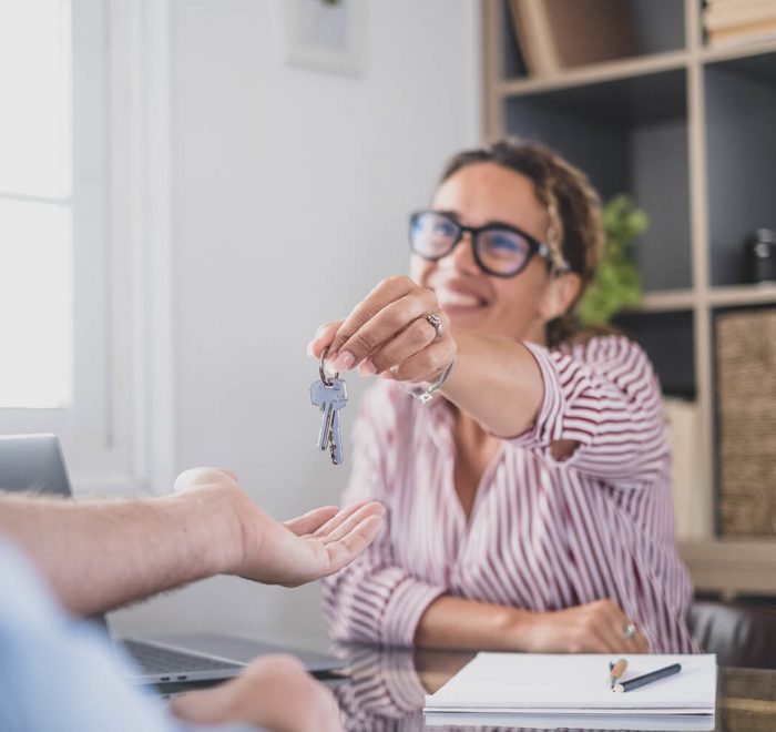 imagen de una empleada de una inmobiliaria entregando unas llaves