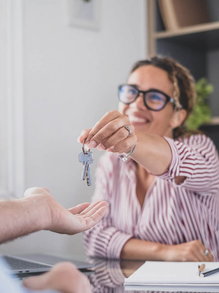 imagen de una empleada de una inmobiliaria entregando unas llaves