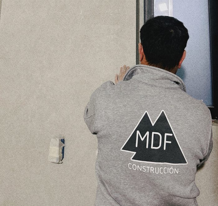 trabajador del equipo de MDF Construcción alicatando un baño