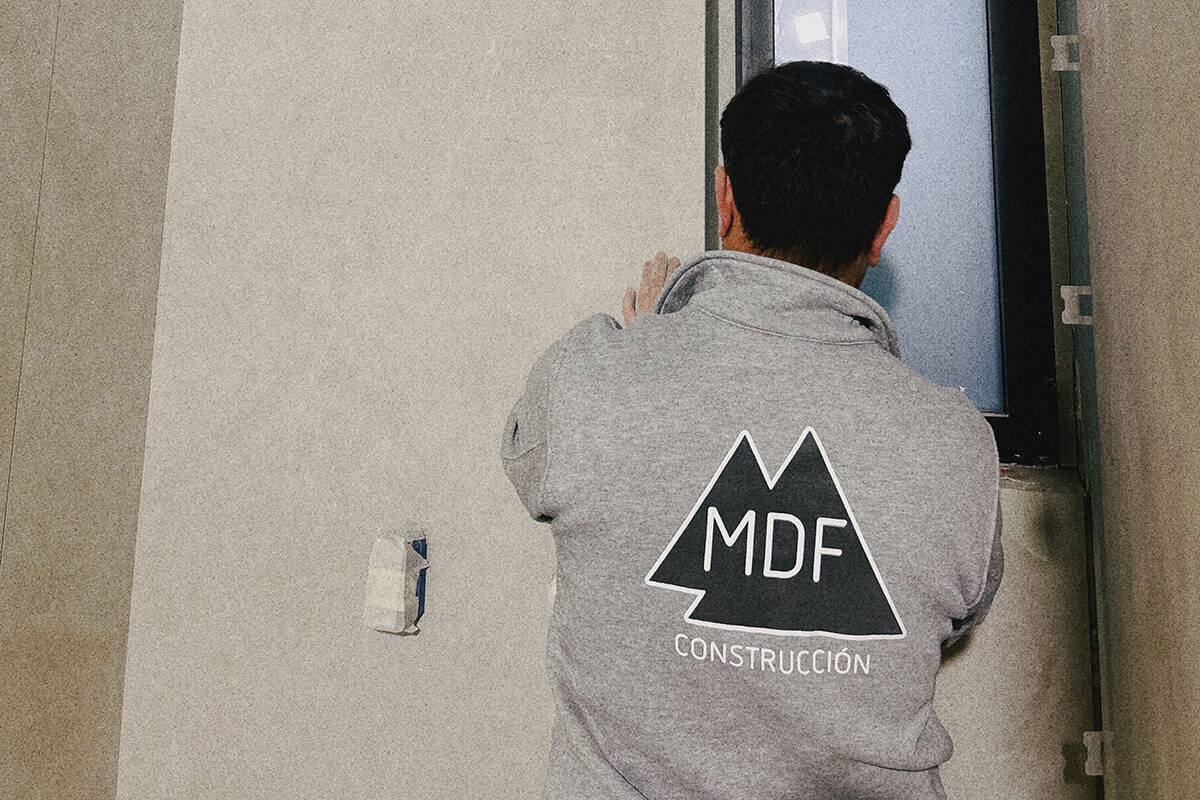trabajador del equipo de MDF Construcción alicatando un baño