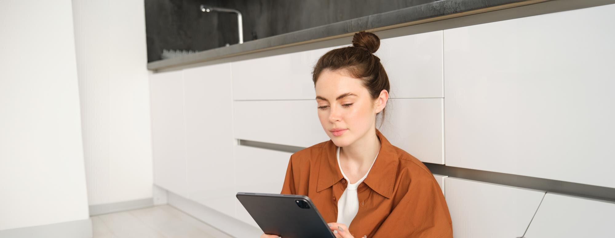 Chica con una tablet trabajando en la cocina