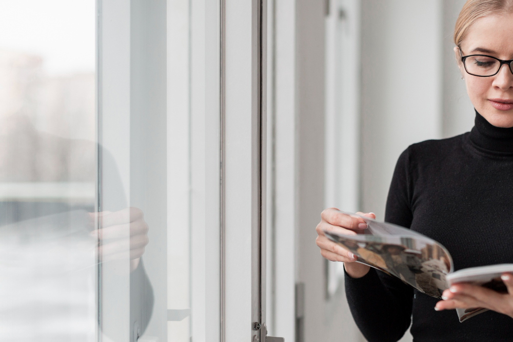 mujer leyendo cerca de una ventana